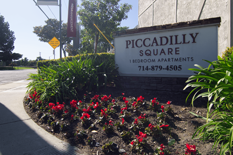 A sign for Piccadilly Square Bedroom Apartments is in front of a building.